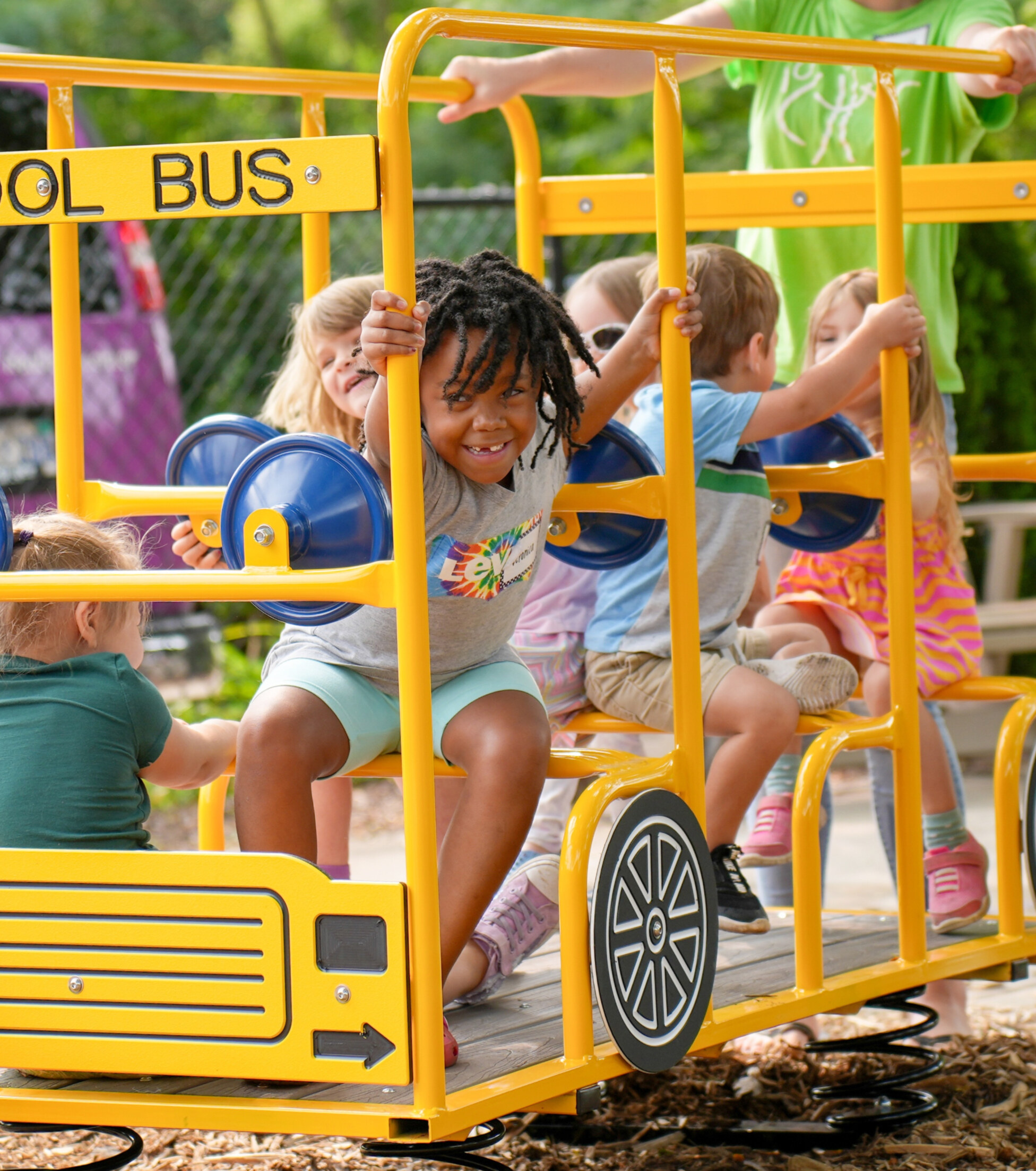 A child playing on a bus playground equipment